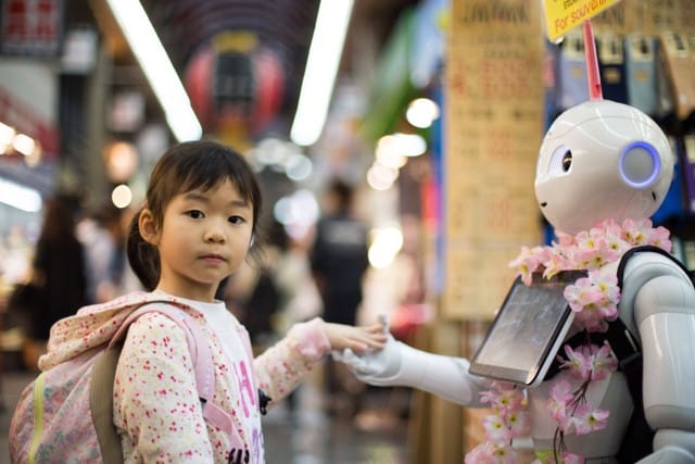 una bambina che tiene per mano un root della sua altezza su uno sfondo urbano