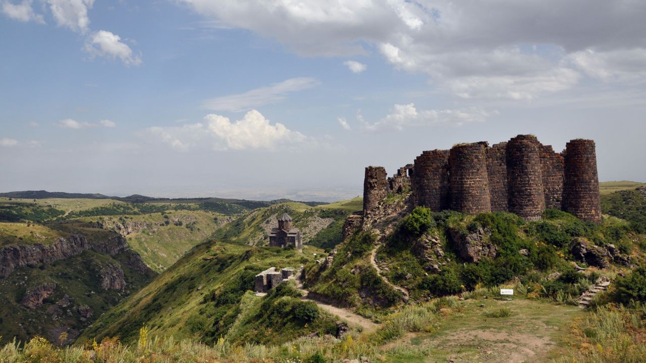 una fortezza in pietra su delle colline verdi