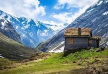 una casa di pietra e legno tra le vallate verdi e innevate della norvegia, simboleggia il friluftsliv