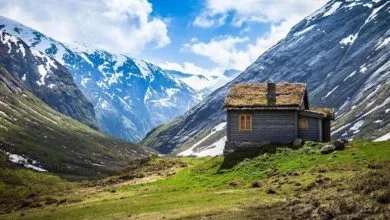 una casa di pietra e legno tra le vallate verdi e innevate della norvegia, simboleggia il friluftsliv