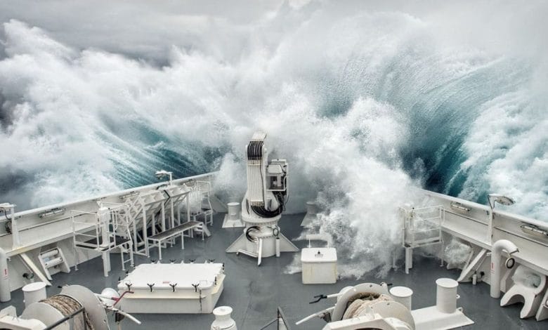 la poppa di una nave che si infrange contro un'onda anomala nell'oceano