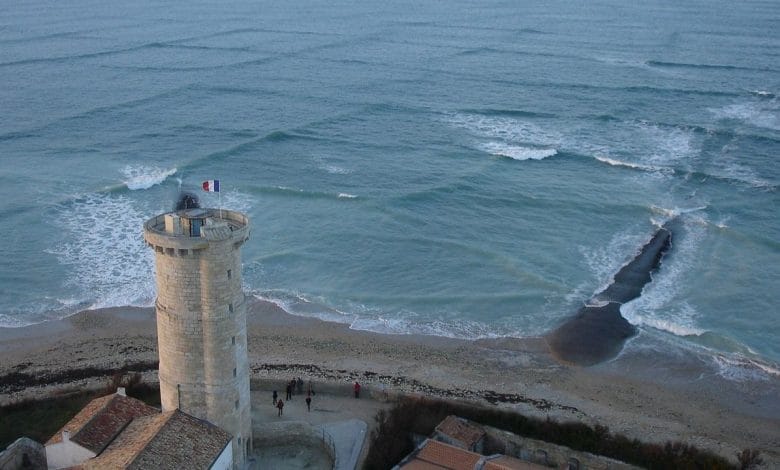 vista dall'alto delle onde quadrate nel mare, con una torre in secondo piano