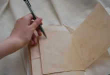 una mano che scrive su un foglio, la mano è chiaramente la sinistra che indica utilizzatore mancino
