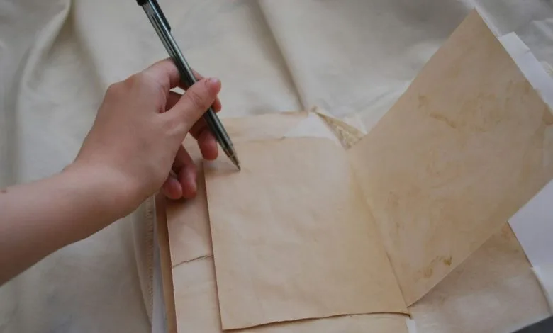 una mano che scrive su un foglio, la mano è chiaramente la sinistra che indica utilizzatore mancino