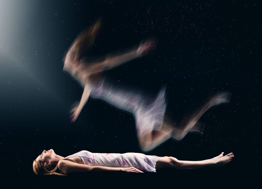 una donna con vestito bianco sdraiata sul dorso che sembra avere un'esperienza extracorporea con una sorta di anima che le esce dal corpo