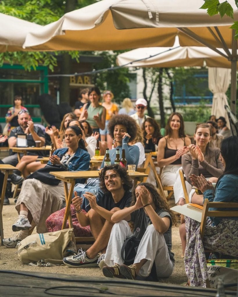 un gruppo di persone divertito e sorridente in un giardino, c'è chi è in piedi e chi seduto