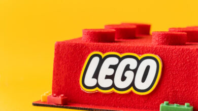 Logo della lego su un mattoncino in feltro rosso. il background è giallo