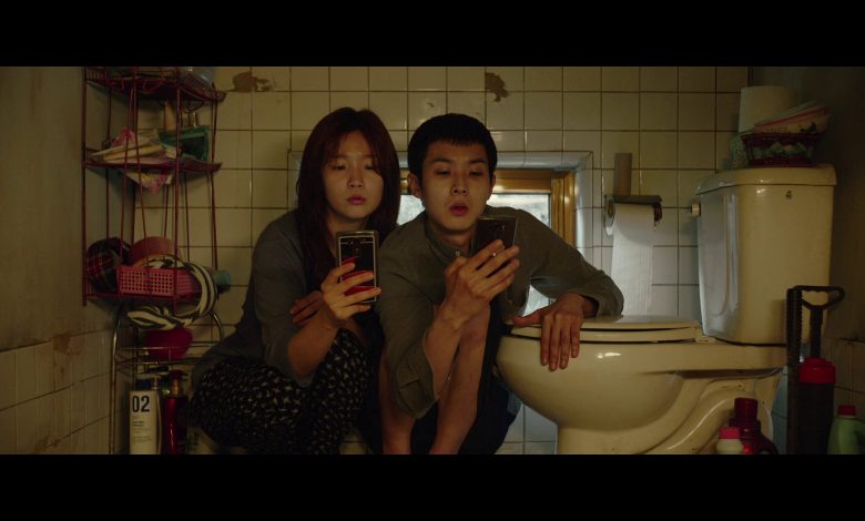 una scena del film parasite dove due persone cercano di comunicare con uno smartphone