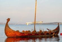 replica di una caravella vichinga che solca le placide acque di un fiume