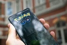 uno smartphone con il logo di pokemon go tenuto in mano da una mano di un uomo