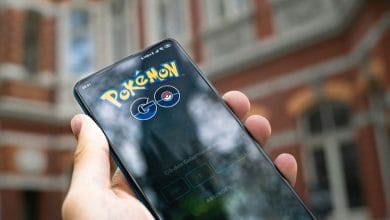 uno smartphone con il logo di pokemon go tenuto in mano da una mano di un uomo