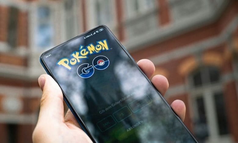 uno smartphone con il logo di pokemon go tenuto in mano da una mano di un uomo