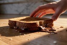 un sandwich con la nutella o cioccolata che cade per terra