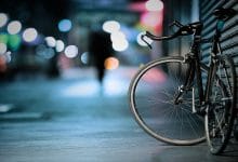 un foto di una bici appoggiata su una saracinesca, in un contesto urbano