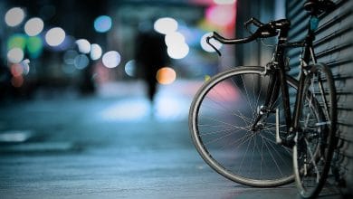 un foto di una bici appoggiata su una saracinesca, in un contesto urbano