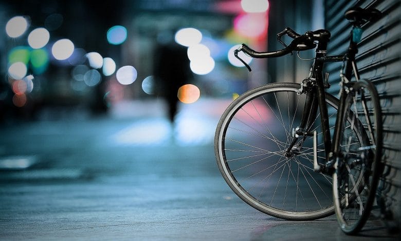 un foto di una bici appoggiata su una saracinesca, in un contesto urbano