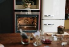 dettagli di una cucina dove si vede un forno e un frigo sullo sfondo