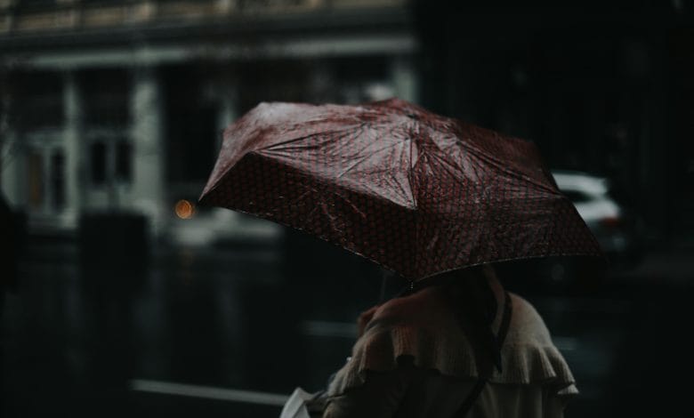 Una donna si protegge dalla pioggia con un ombrello