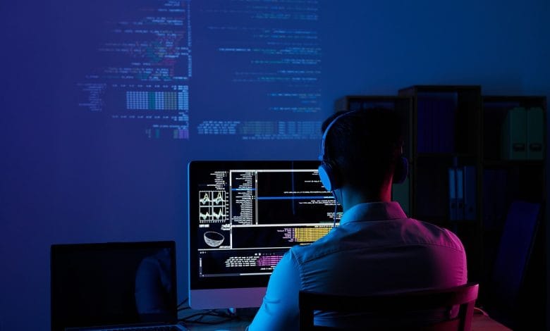 una persona lavora alla sua scrivania, circondato da tecnologia